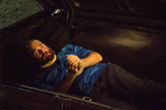 WILL FORTE as Hulka with wrists tied with rope in trunk of car