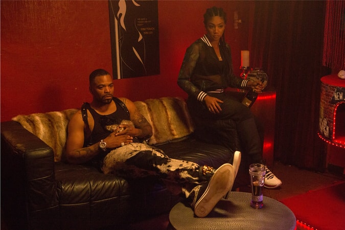 METHOD MAN as Cheddar holding Keanu the kitten and TIFFANY HADDISH as Hi-C sitting on a couch in a room painted red