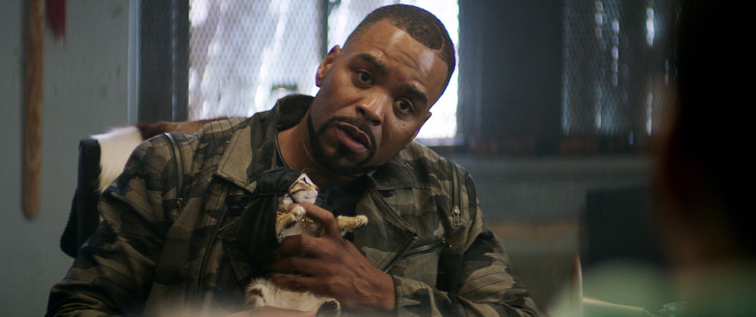 METHOD MAN as Cheddar holding Keanu the kitten who is wearing a black headwrap and gold chain