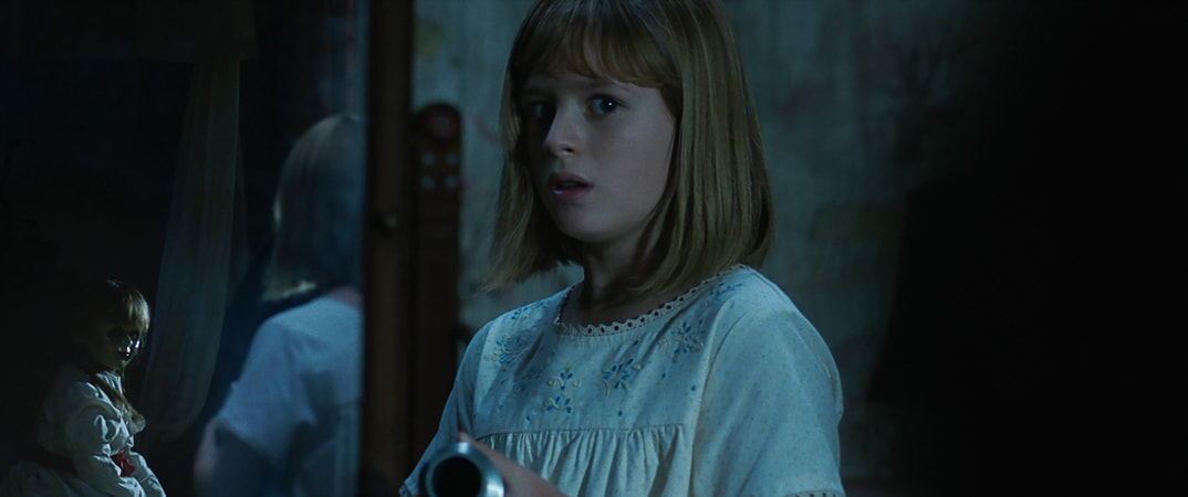 The Annabelle doll and LULU WILSON as Linda in New Line Cinema's supernatural thriller "ANNABELLE: CREATION," a Warner Bros. Pictures release.